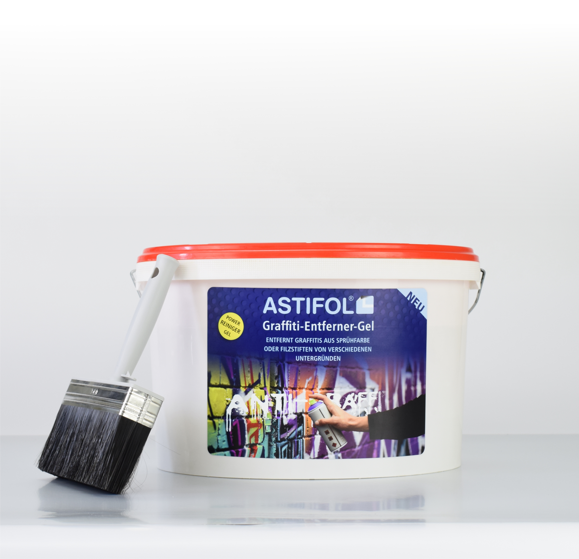 Ein großer Eimer Astifol Entferner-Gel an den ein großer Pinsel angelehnt ist.